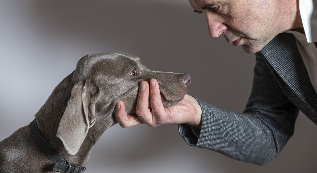 Man holding dogs head looking it into the eyes. Photo: Circlephoto, Dreamstime